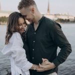 Happy couple embracing by the Alster Lake in Hamburg, Germany during a beautiful summer evening.